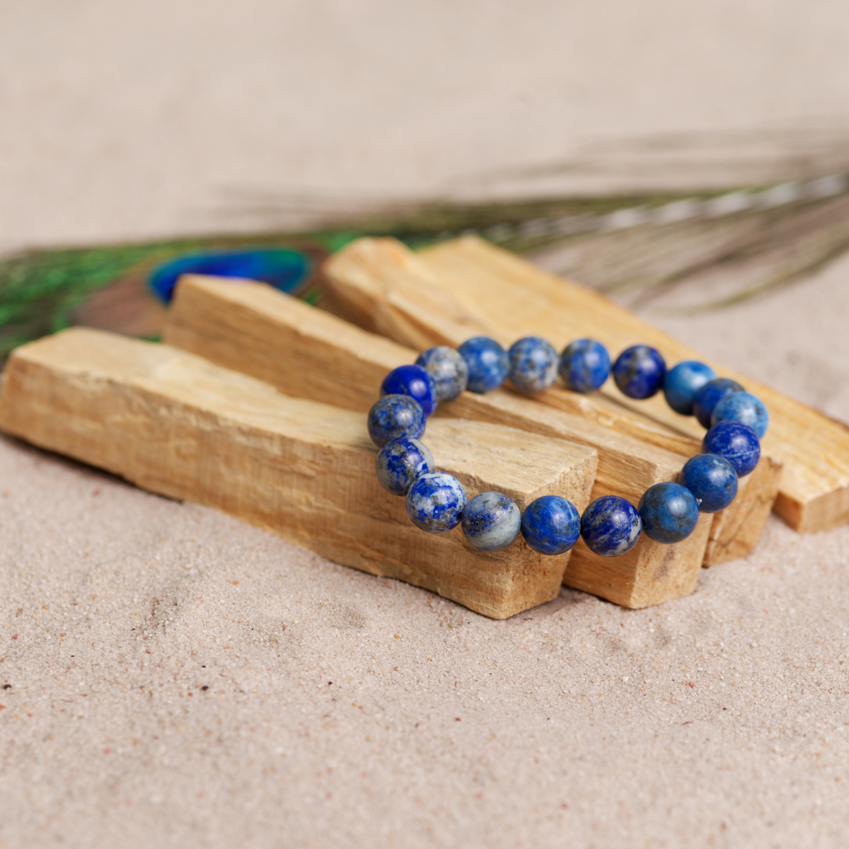 Nærbilde av lapis lazuli perler – dyp blå farge med gyldne detaljer, laget i Norge.
